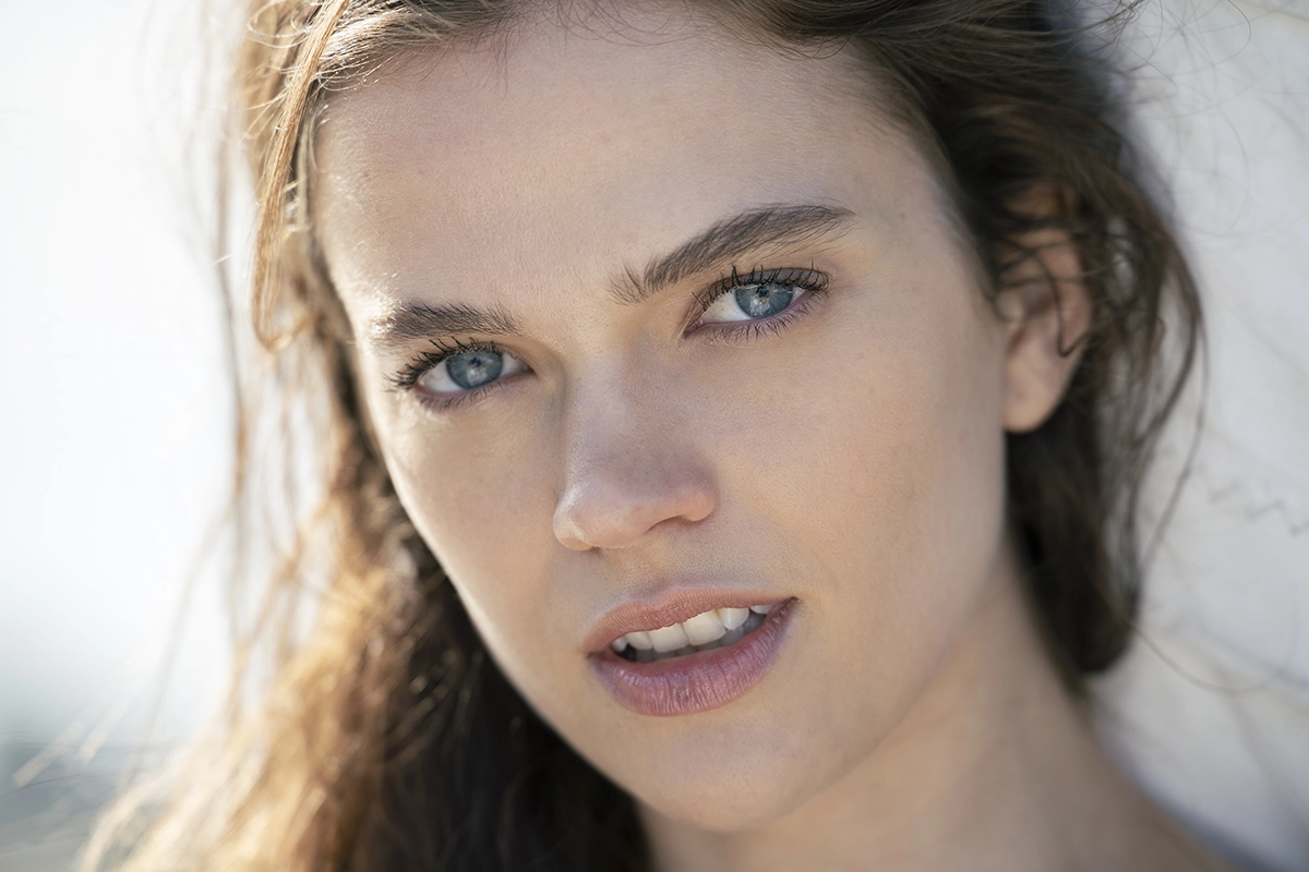 Close-up summer portrait of a woman in natural light, demonstrating soft background blur and summer photography lighting techniques.