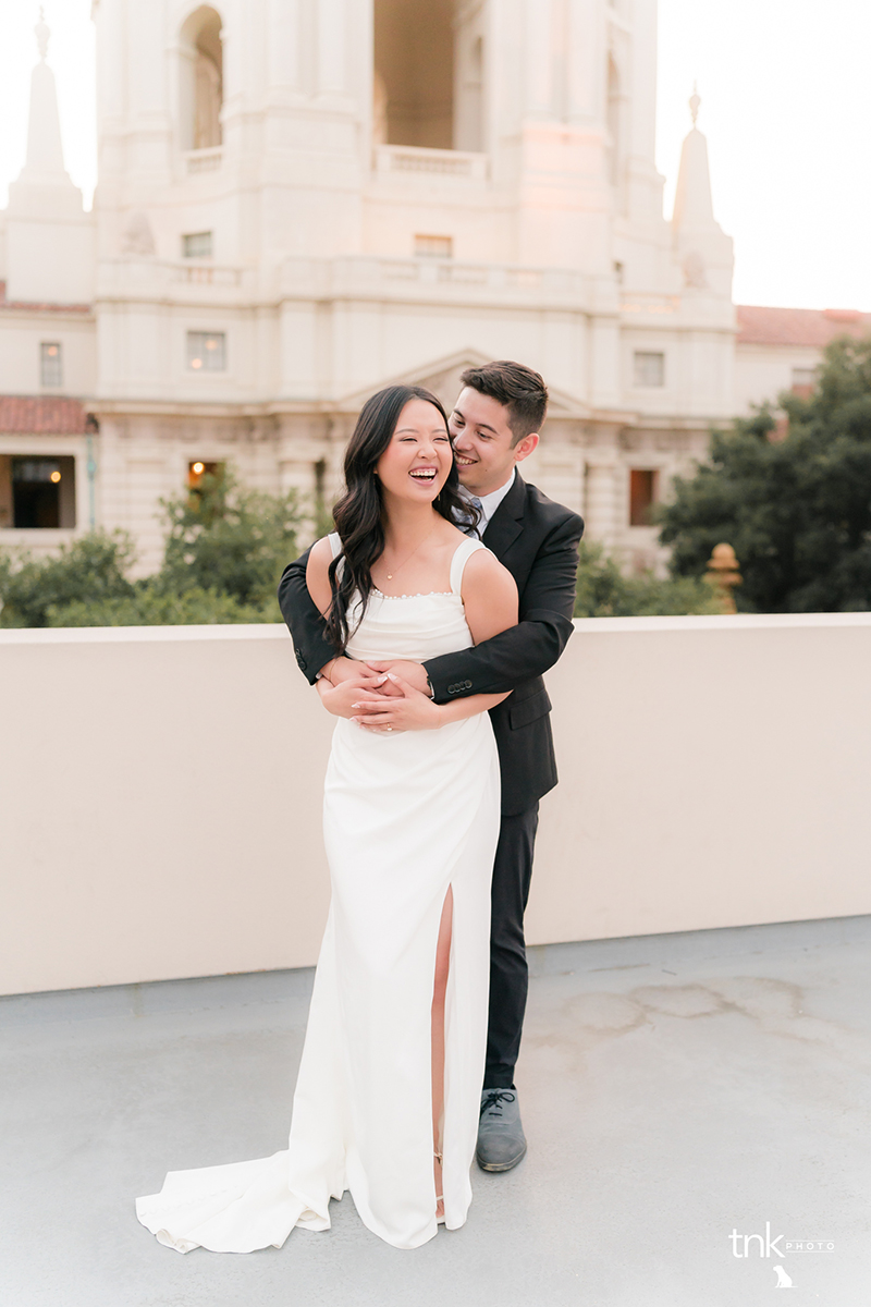 Bride and groom laughing in front of castle