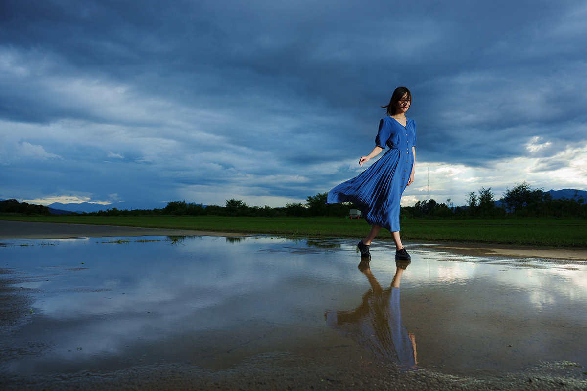 Woman walking near water with grass