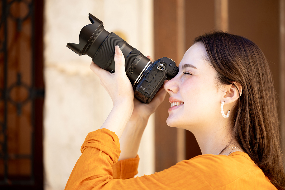 Woman shooting with camera and lens