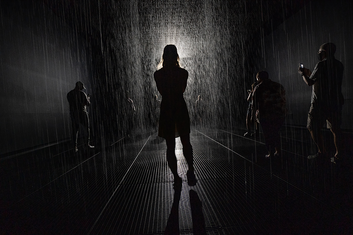 Woman standing in a dark corridor with others against the wall