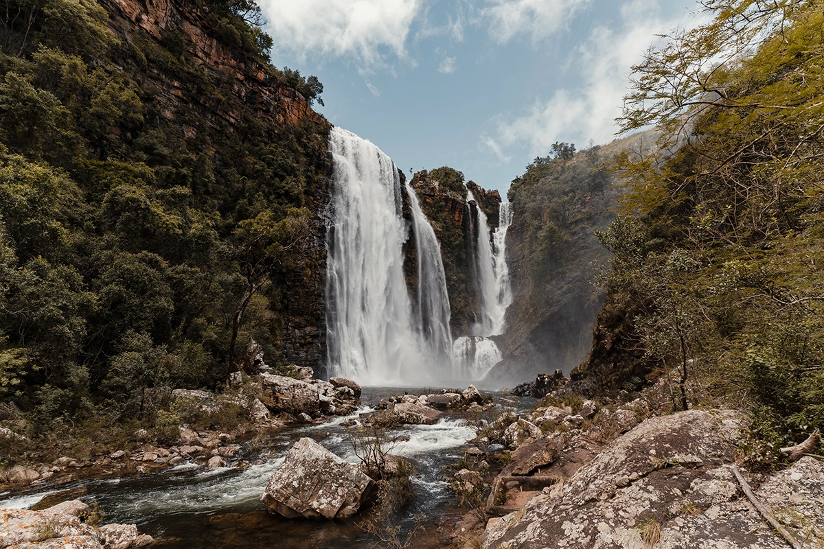 Powerful waterfall cascading through a rocky forest canyon—ideal for applying camping photography tips like long exposure to capture motion.