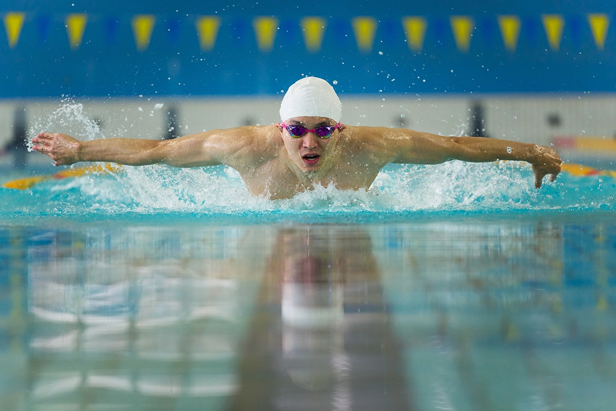 Swimmer in indoor pool shot with one of the best sports photography lenses, the Tamron 70-180mm G2.