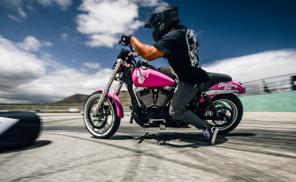 Un tipo en una moto rosa, tomada en una carrera de derrapes en moto.