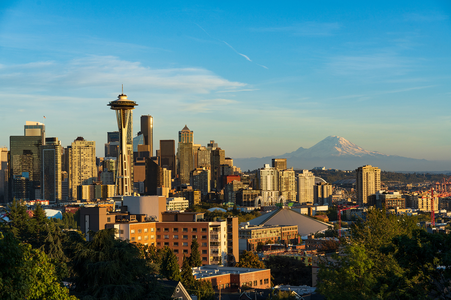 El horizonte de Seattle al atardecer con el Monte Rainier al fondo, resaltando la belleza urbana y natural.