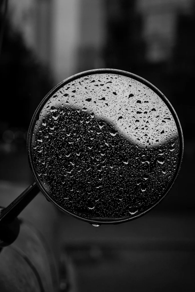 Le rétroviseur latéral rond d'un camion avec des gouttes de pluie.
