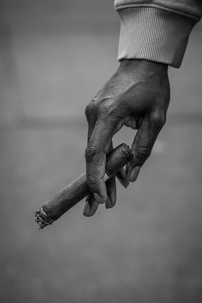 Un cigare qui pend d'une main