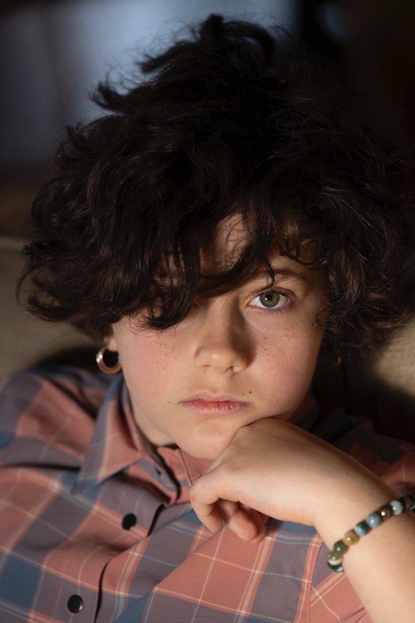 Close-up portrait of a child with soft natural window light highlighting the face—an intimate example of photographing portraits in early morning light.