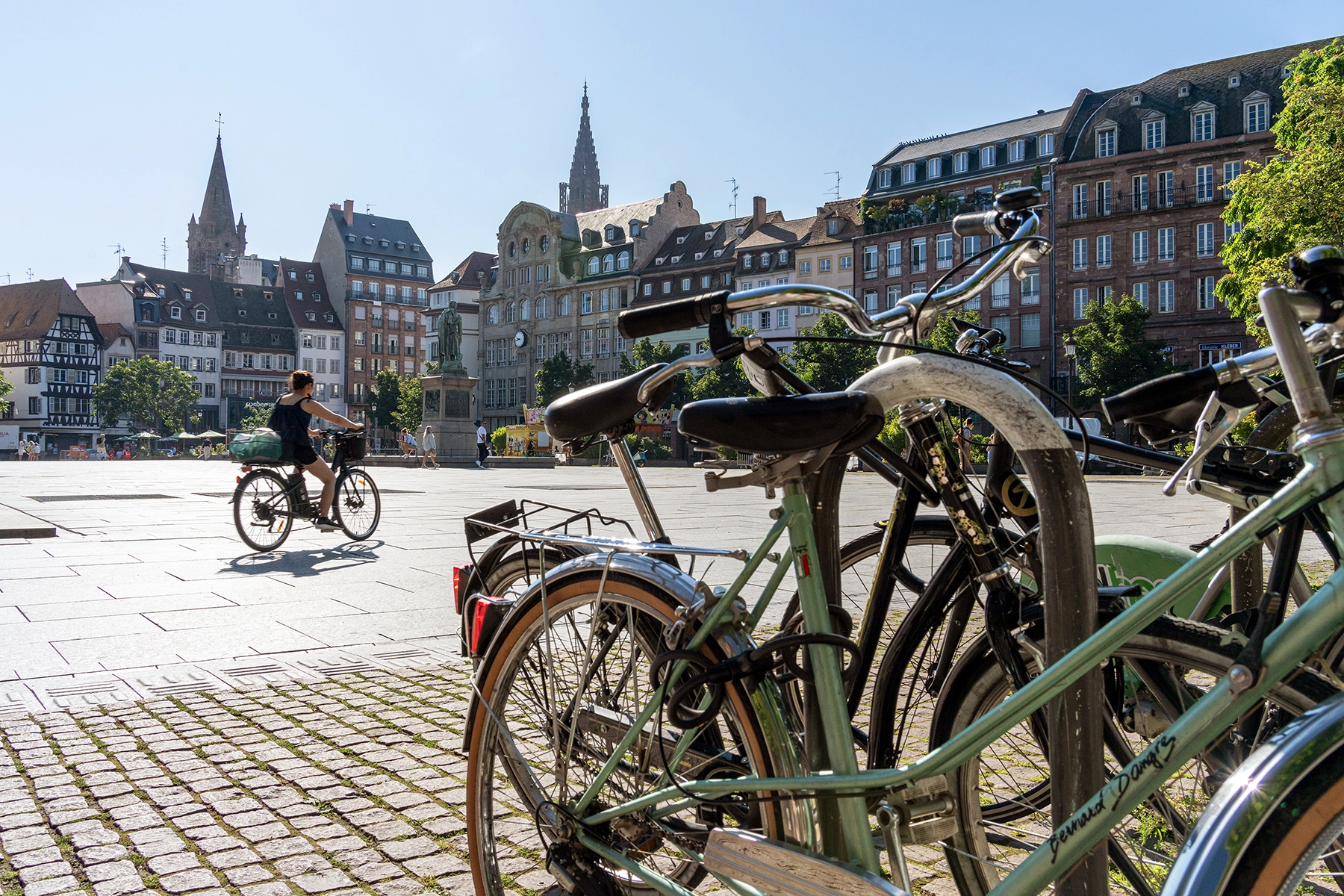 Bicycles parked in the foreground with a cyclist riding through a historic square in Strasbourg, France, an example of Rhine River cruise travel photography shot during excursions.