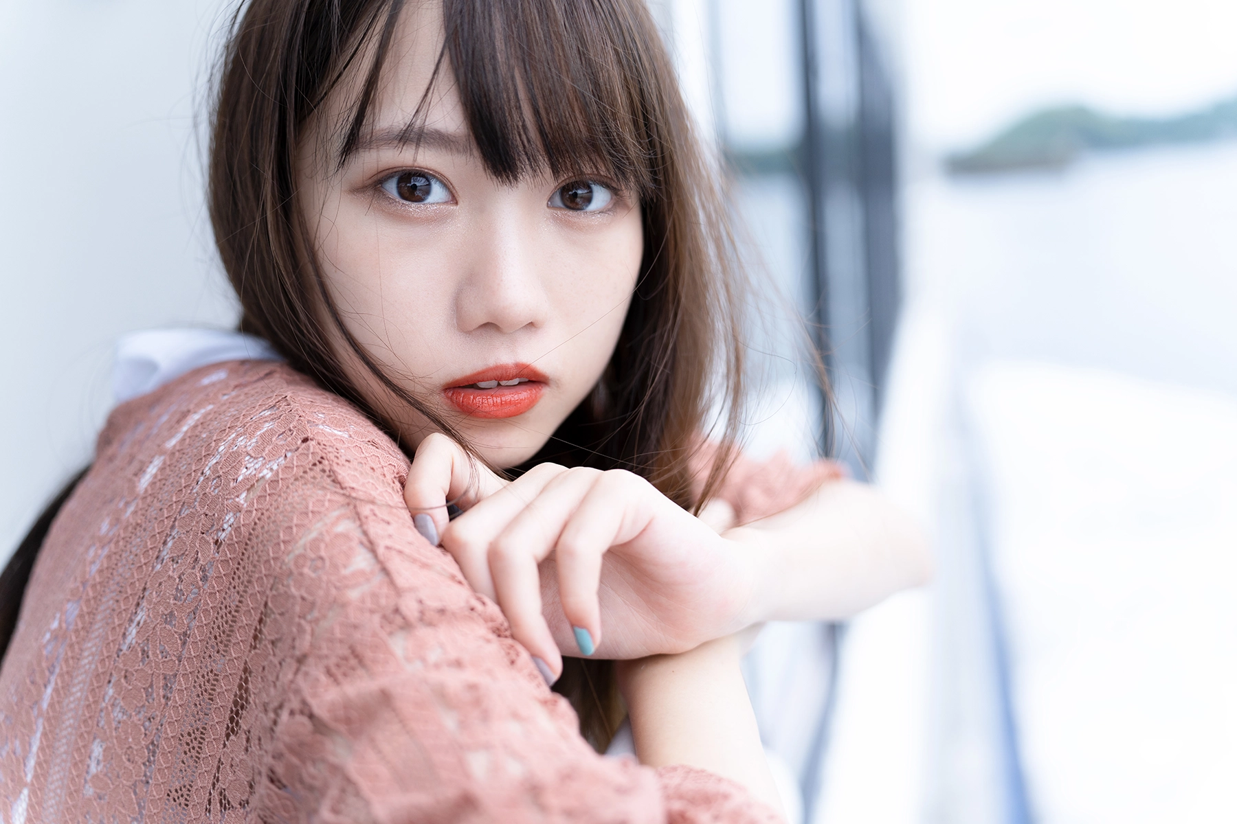 Portrait of a young woman with soft background blur, demonstrating shallow depth of field created using a wide aperture setting, captured with a Tamron lens.