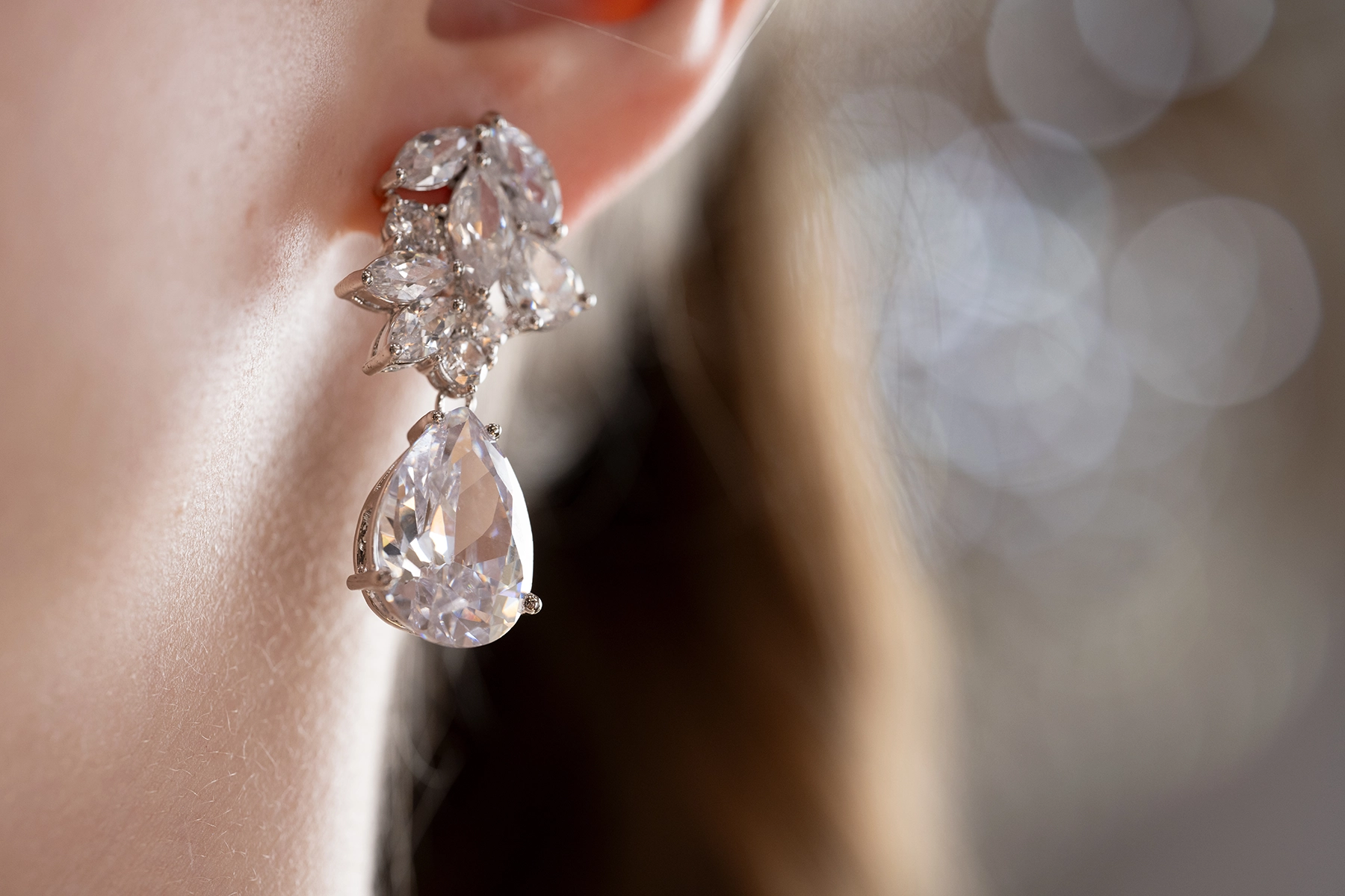 Close-up of a sparkling diamond earring against a softly blurred background.