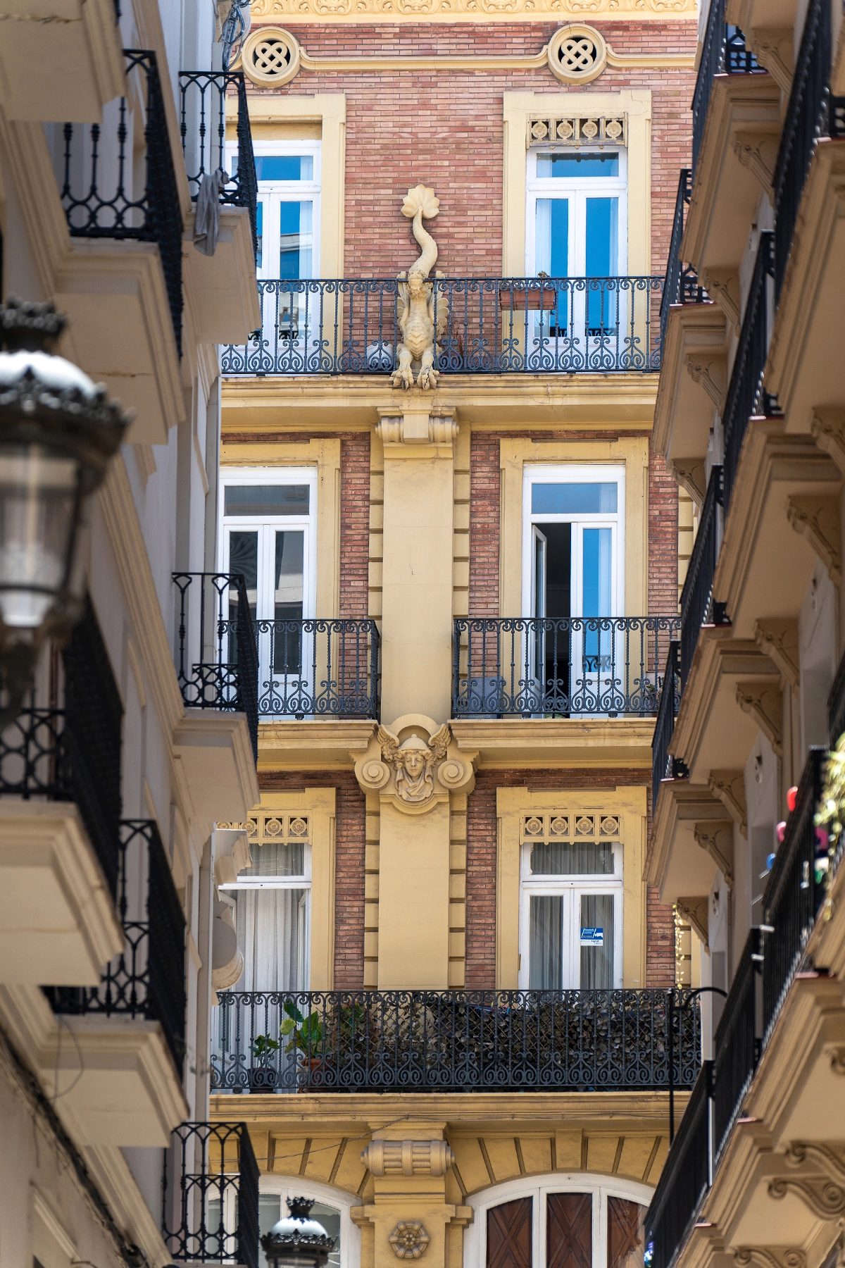 Ornate European building façade viewed through a narrow alley, captured with a medium telephoto lens to emphasize compression and architectural detail.