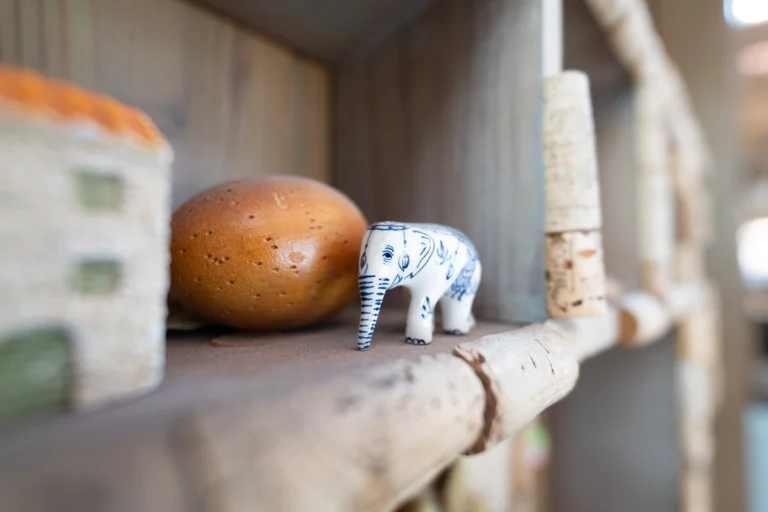 A shelf with objects and an elephant as the focus