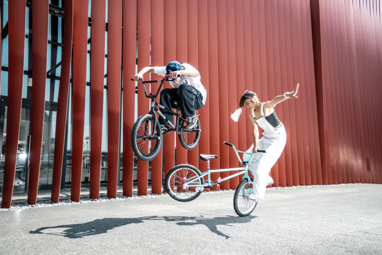A guy and a girl BMX riders doing stunts