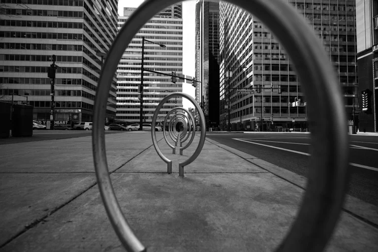 Metal circles built into the sidewalk on the street of a city