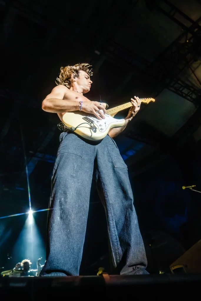 Um guitarrista sem camisa da banda The Driver Era