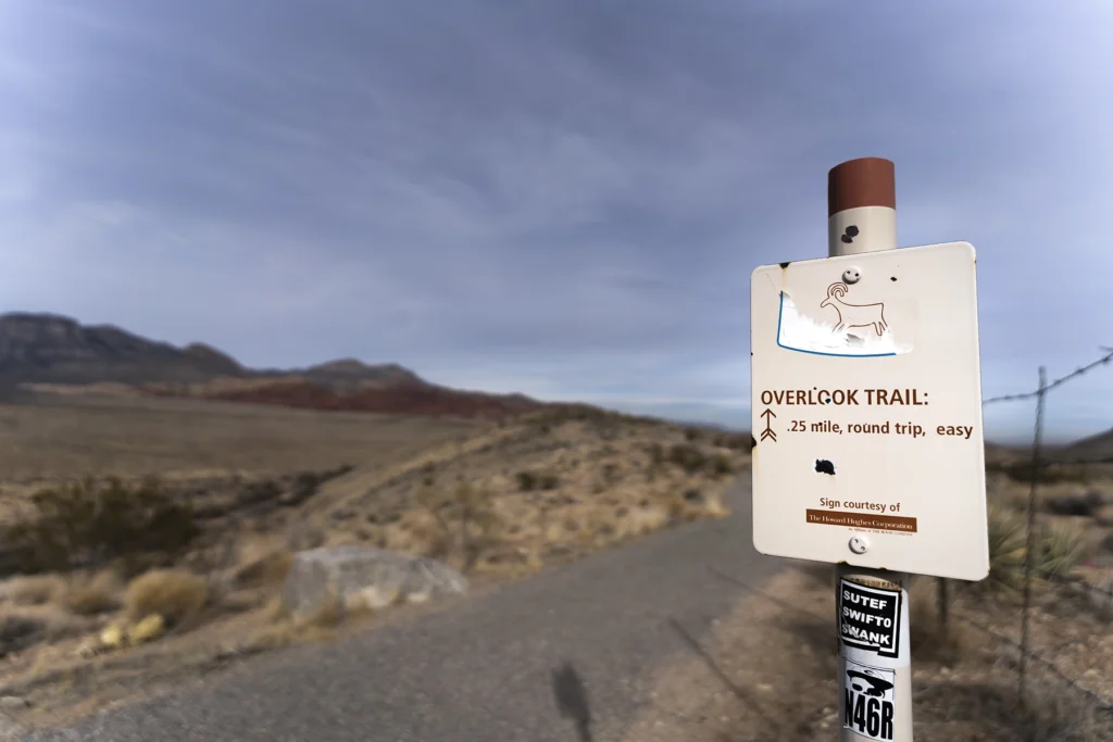 Uma foto da placa da Overlook Trail serve como ponto de referência visual, ajudando os espectadores a se orientarem no ambiente.