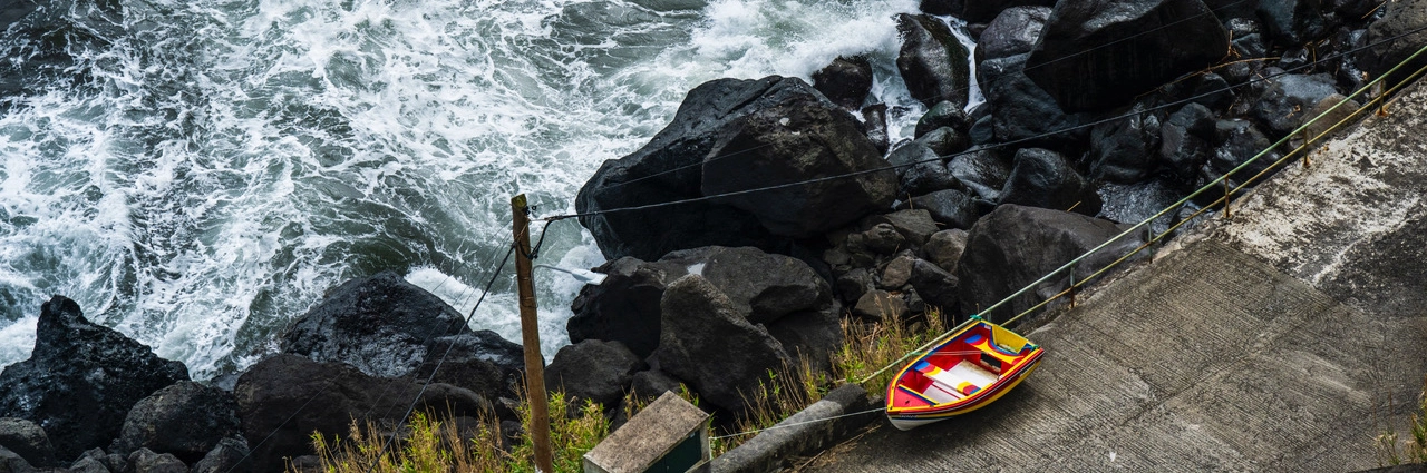 Vibrant boat on São Miguel’s rugged shore – hero image for how to photograph the Azores with bold color and coastal energy.
