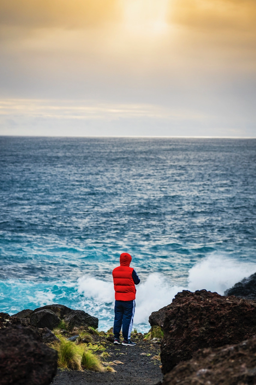 Traveler watching ocean at golden hour – how to photograph the Azores with light and emotion on São Miguel.