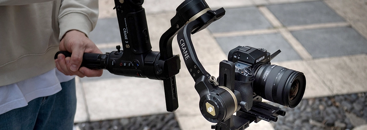 Una cámara Fujifilm con un objetivo zoom Tamron montada en un cardán de mano profesional, demostrando el trabajo de cámara estabilizada para una grabación de vídeo fluida.