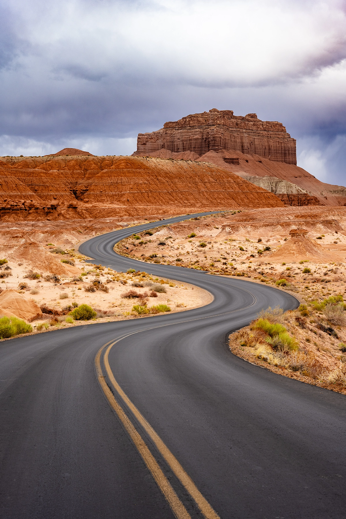 Carretera con curva en S en Goblin Valley que conduce a la colina del fondo