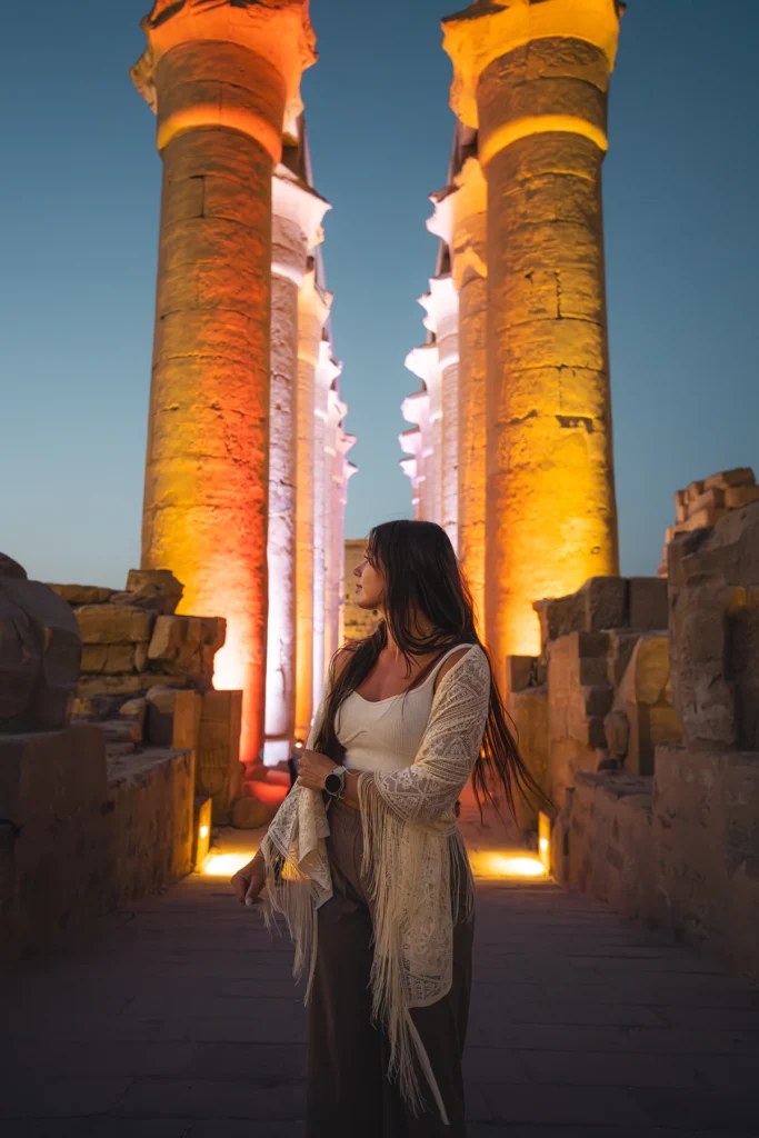 Mujer de pie delante de pilares iluminados