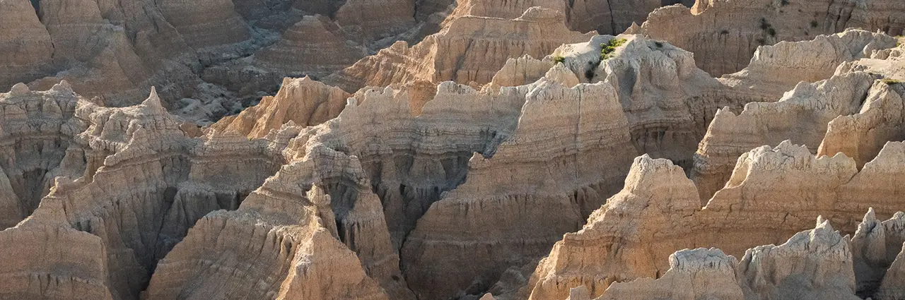 Photographing the Badlands rugged rock formations at sunrise with Tamron lenses.