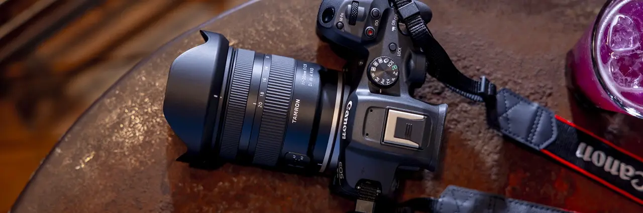 Câmera sem espelho Canon EOS R com uma lente Tamron 11-20mm F/2.8 de montagem RF apoiada em uma mesa, destacando a compatibilidade da montagem RF da Canon.