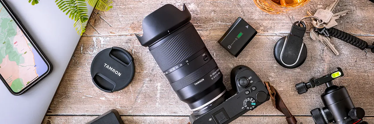 Tamron all-in-one zoom lens on camera with travel gear accessories