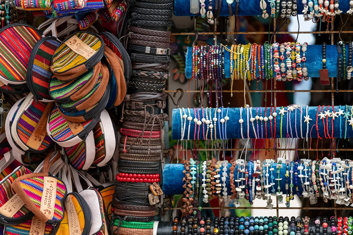 Colorful handmade bracelets and wallets displayed at a street market, captured with the best lens for street photography.