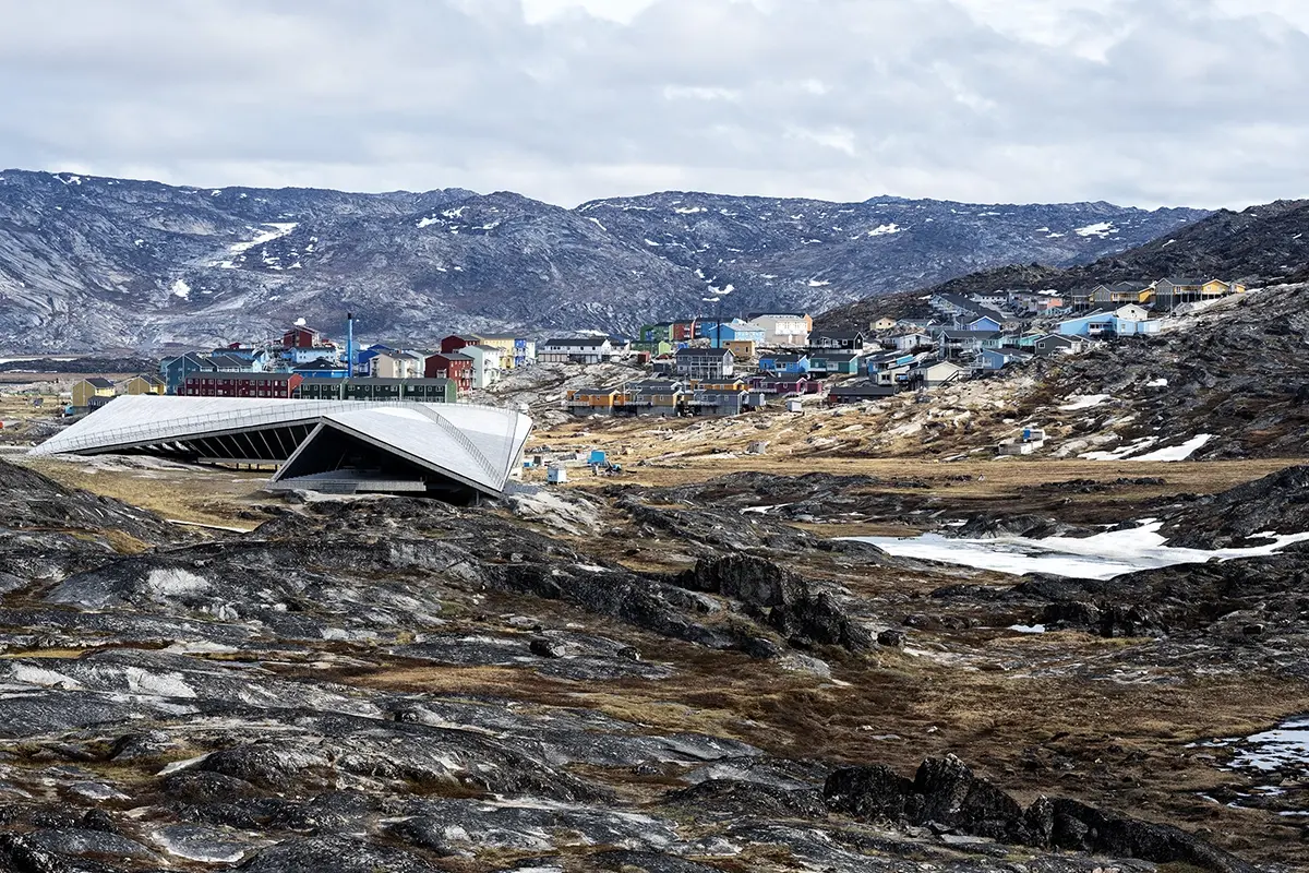 Ilulissat town in Greenland with colorful houses and the Icefjord Centre, photographed with a Tamron telephoto G2 lens against rugged Arctic mountains