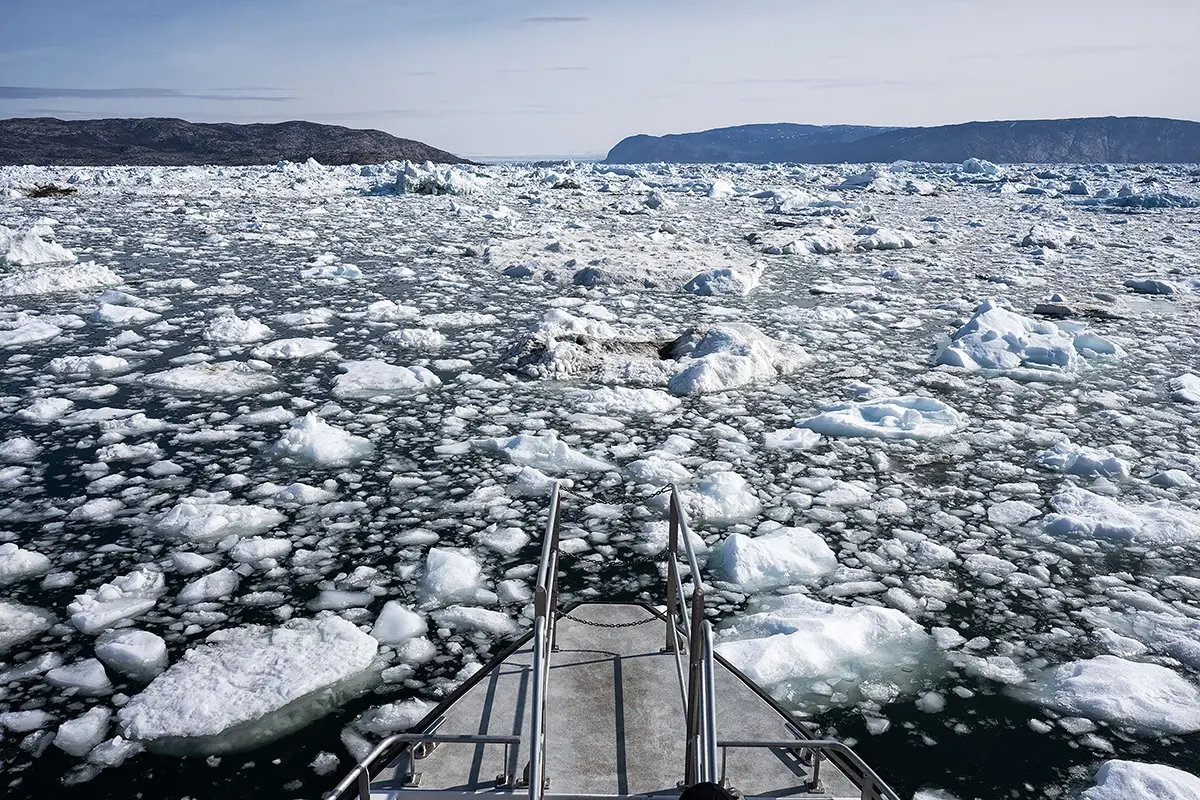 View from a boat navigating through sea ice in Disko Bay, Greenland, photographed with a Tamron wide-angle G2 lens to capture Arctic textures and frozen seascape