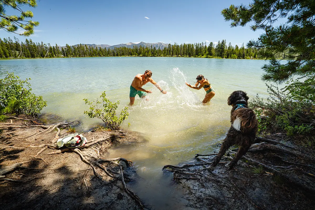 Ajoutez de l'action à vos photos de voyage, comme cette bataille d'eau ludique au bord d'un lac, sous le regard d'un chien.