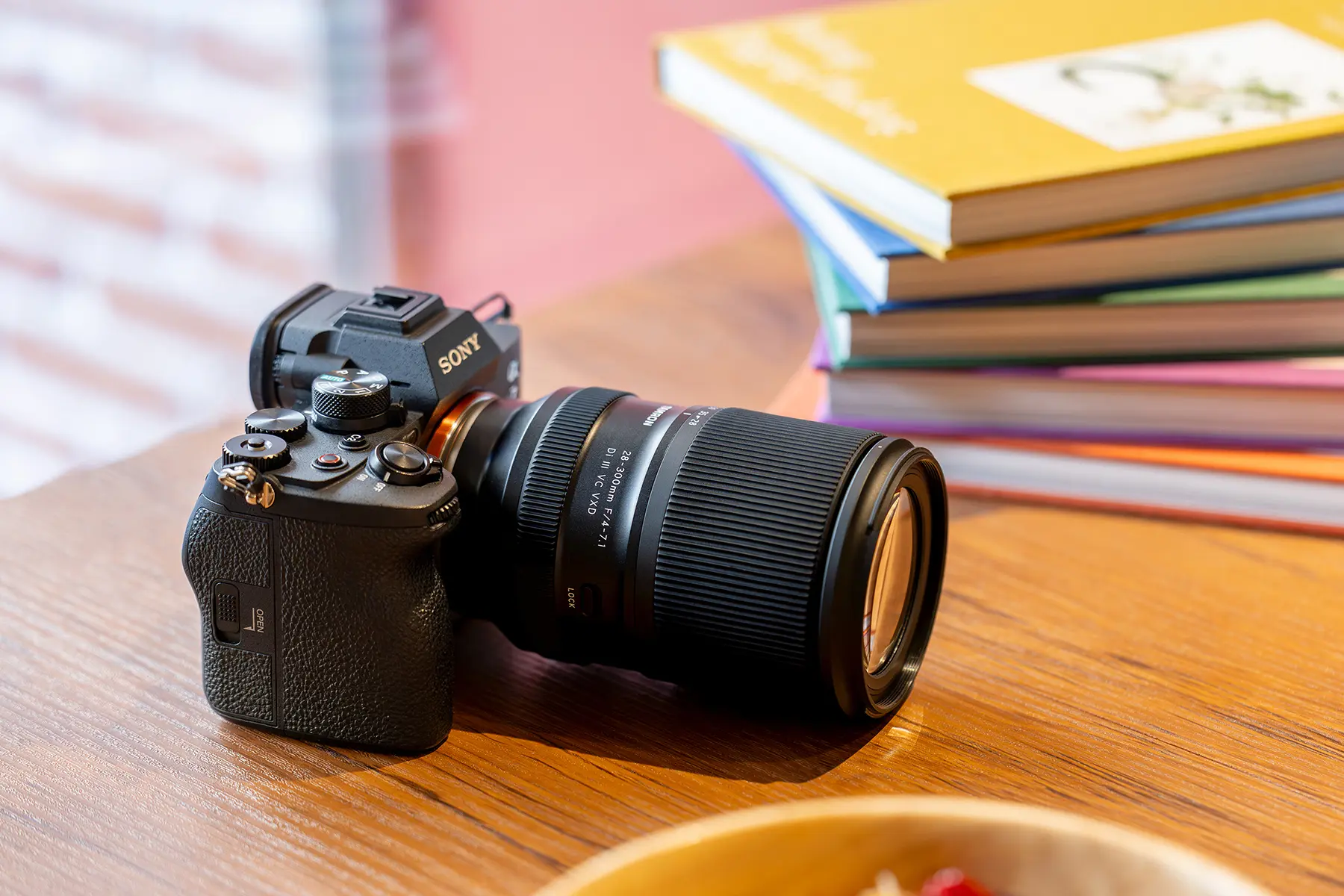 Appareil photo Sony avec objectif zoom Tamron tout-en-un posé sur une table en bois
