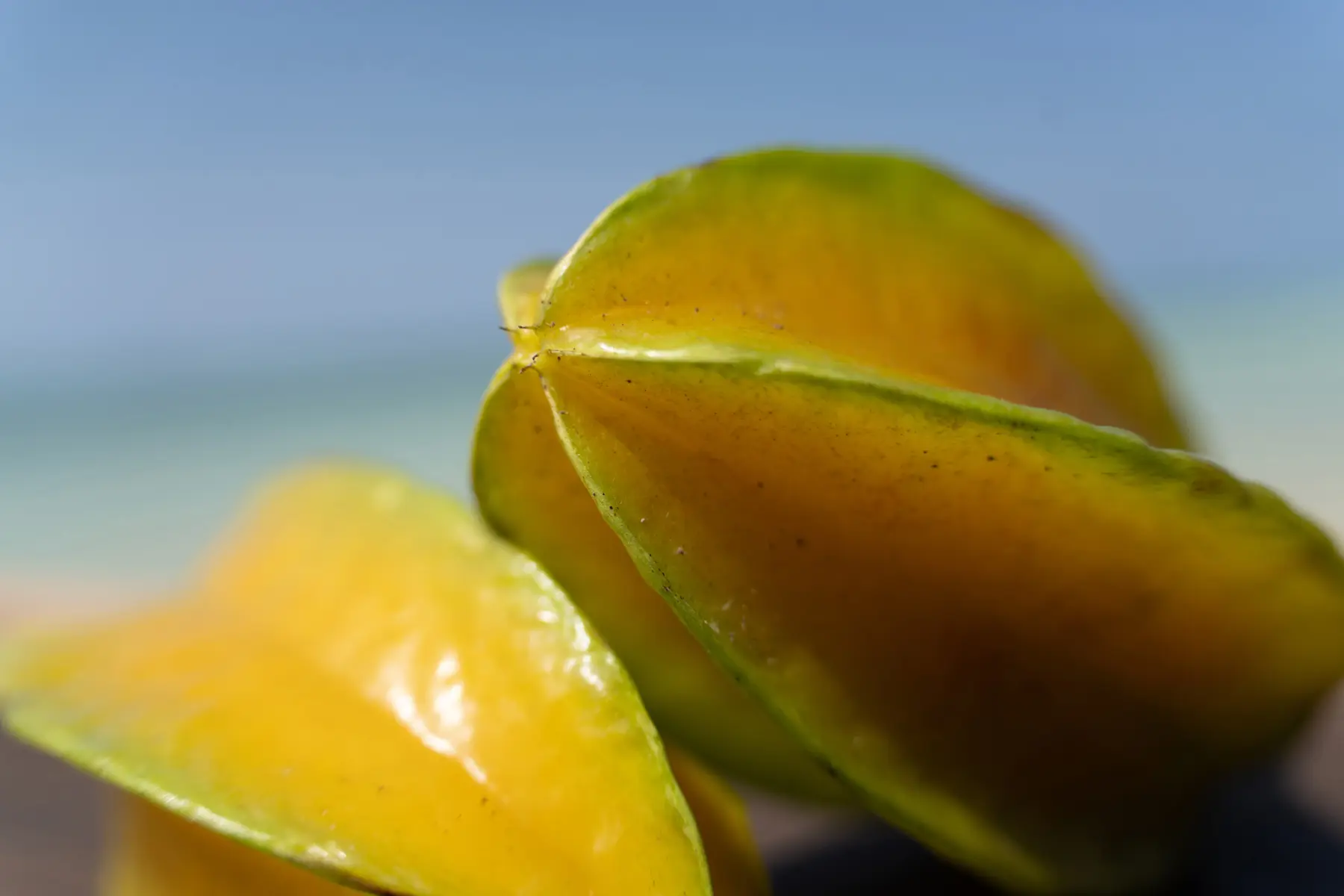 Gros plan d'une carambole jaune mûre sur un fond de plage flou