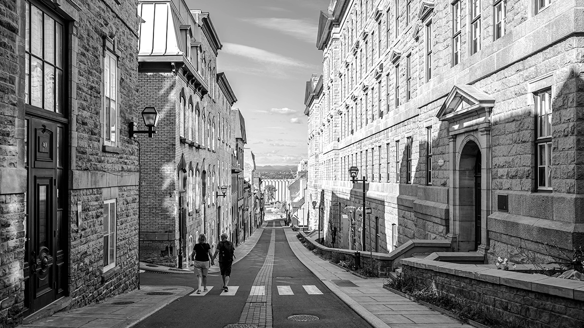Escena urbana en blanco y negro fotografiada con el gran angular Tamron 16-30 mm F/2,8 Di III VXD G2, que muestra su potencia para la fotografía de viajes y arquitectura con líneas nítidas y profundidad.