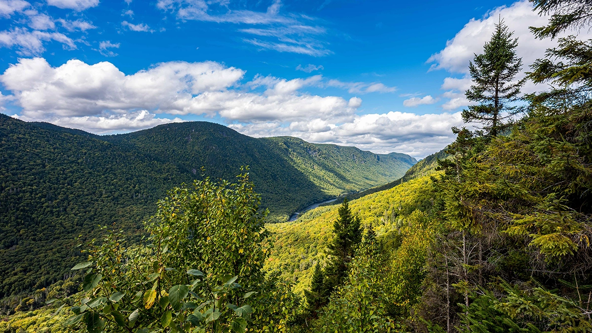 Vista de un valle de montaña fotografiada durante una excursión con el objetivo gran angular Tamron 16-30 mm F/2,8 Di III VXD G2, el mejor objetivo zoom gran angular para fotografía de paisajes y aventuras de viaje.