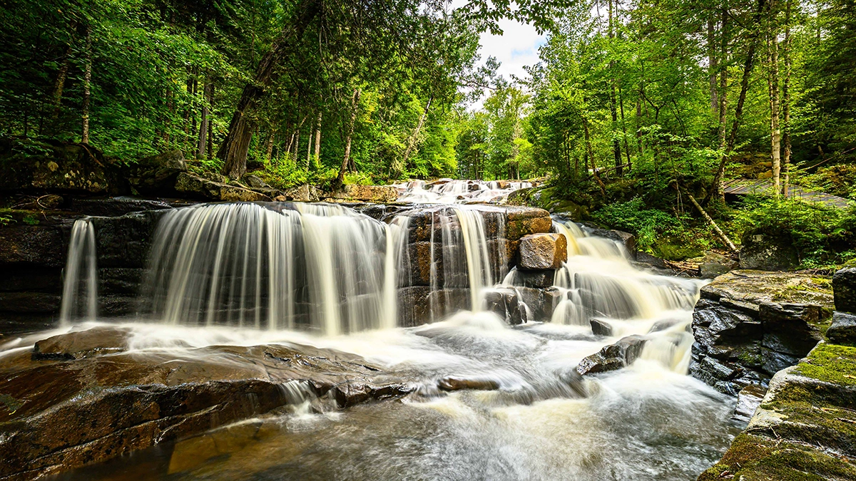 Cascada en el bosque fotografiada con el Tamron 16-30mm F/2.8 Di III VXD G2, utilizando un objetivo gran angular y un filtro ND para capturar el desenfoque de movimiento, ideal para fotografía de paisajes y escenas de viajes.