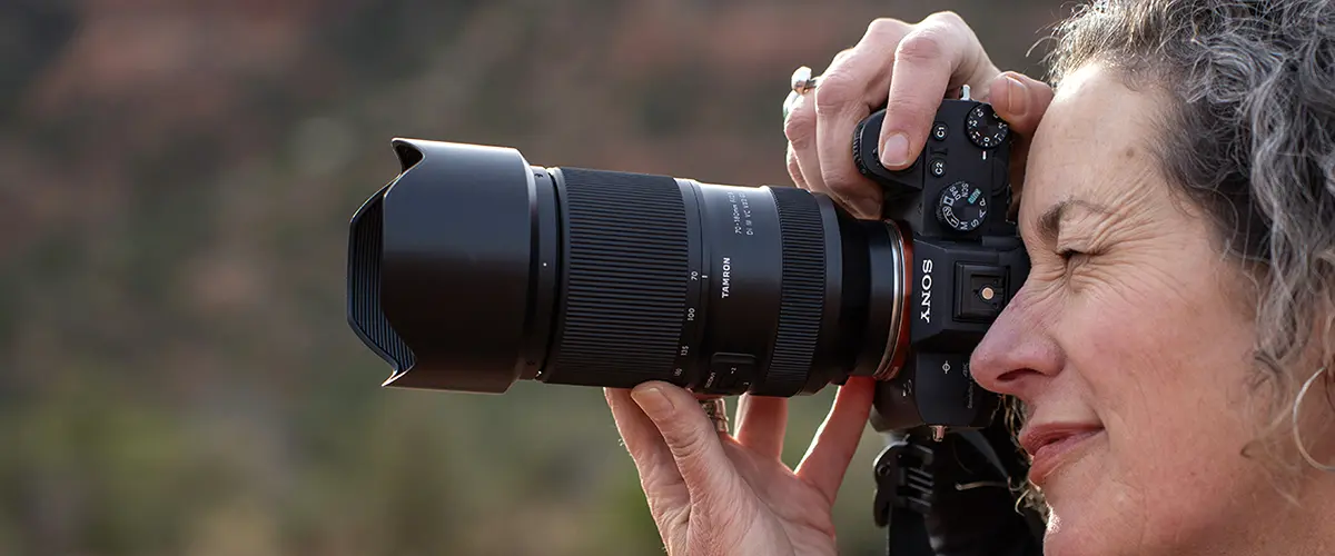 Photographer capturing outdoor landscapes with a Tamron lens.