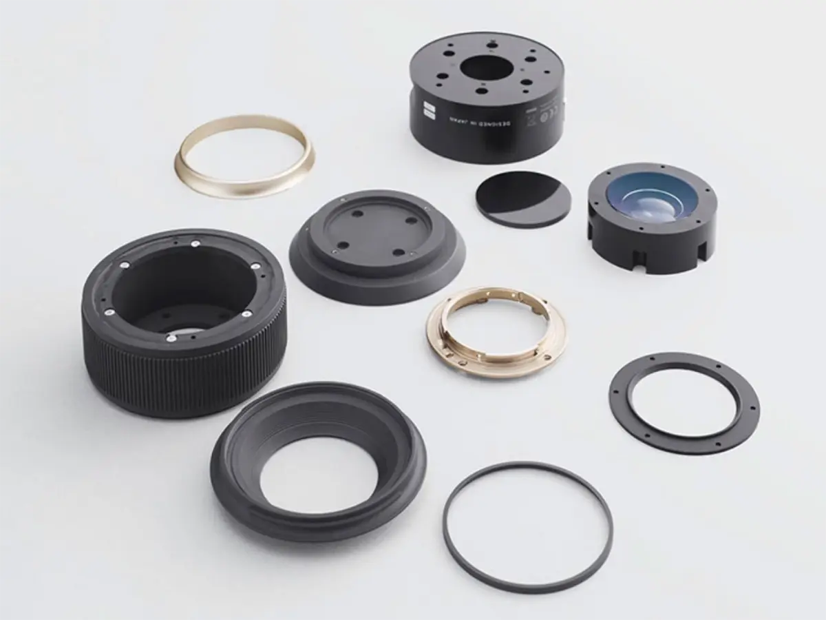 Tamron lens parts and components displayed, illustrating precision engineering.