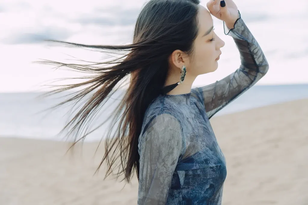 Woman in flowing hair portrait on the beach, captured for the Tamron brand story project.