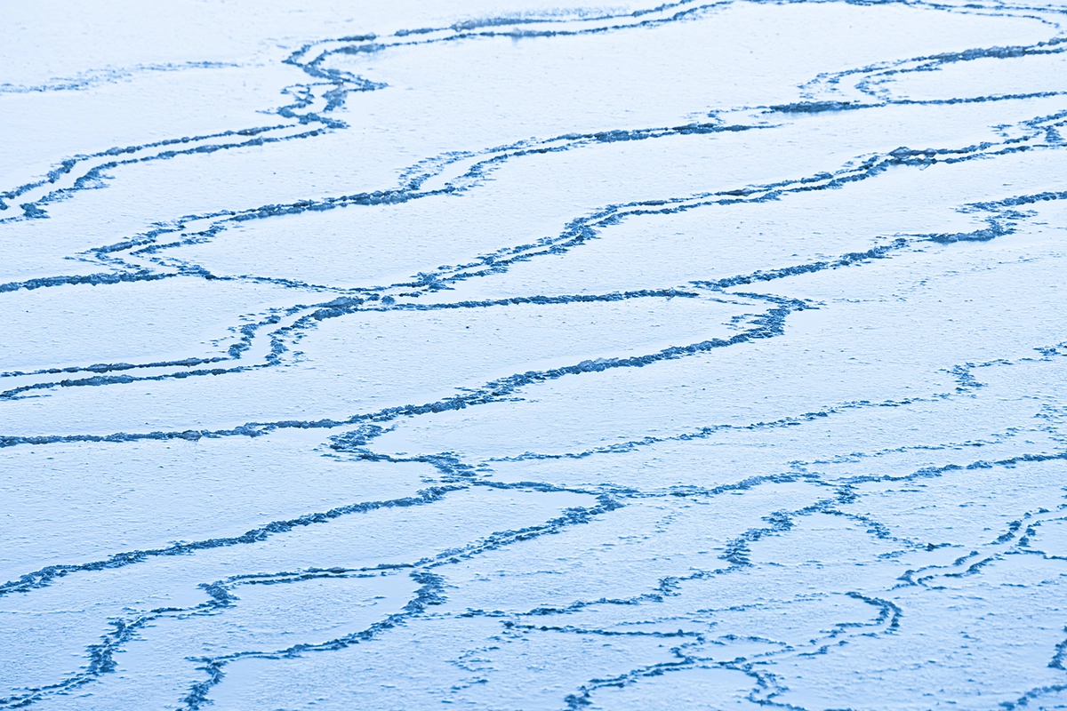 Abstract ice patterns on a frozen surface in a minimalist winter landscape in Hokkaido, Japan