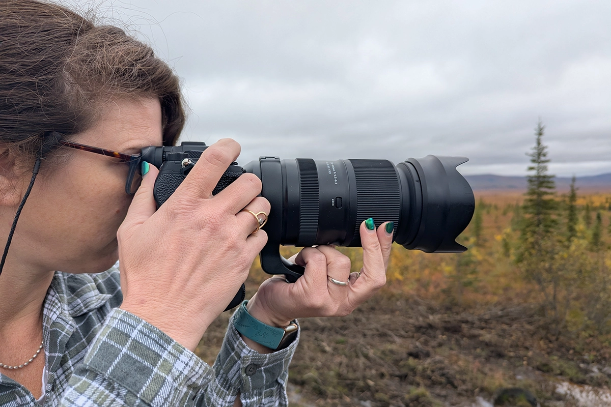 Alyce Bender tient l'appareil photo avec l'objectif Tamron pour photographier les couleurs de l'automne en Alaska.