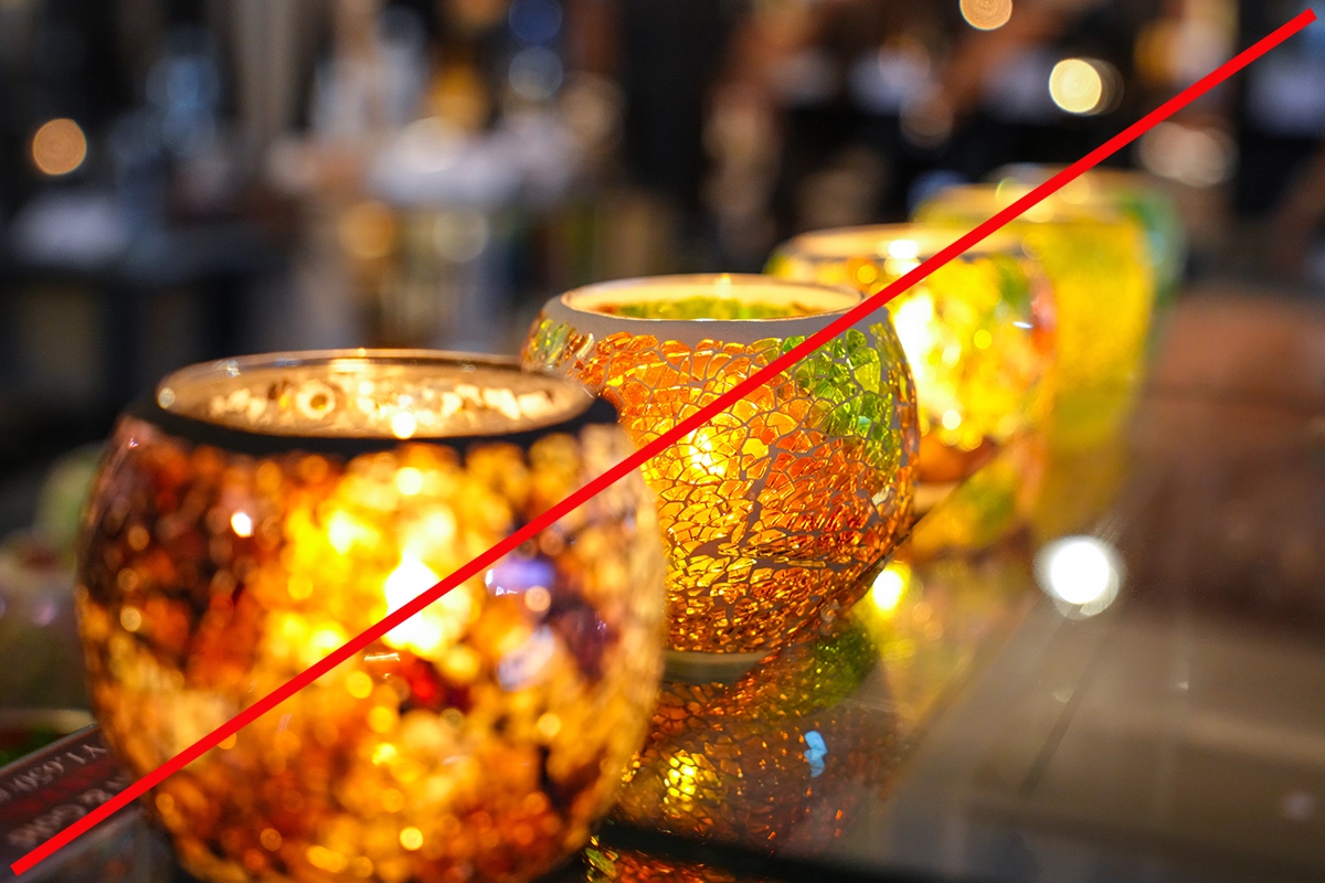 Rangée de bougeoirs en mosaïque colorée avec une ligne diagonale rouge en surimpression, démontrant une composition diagonale.