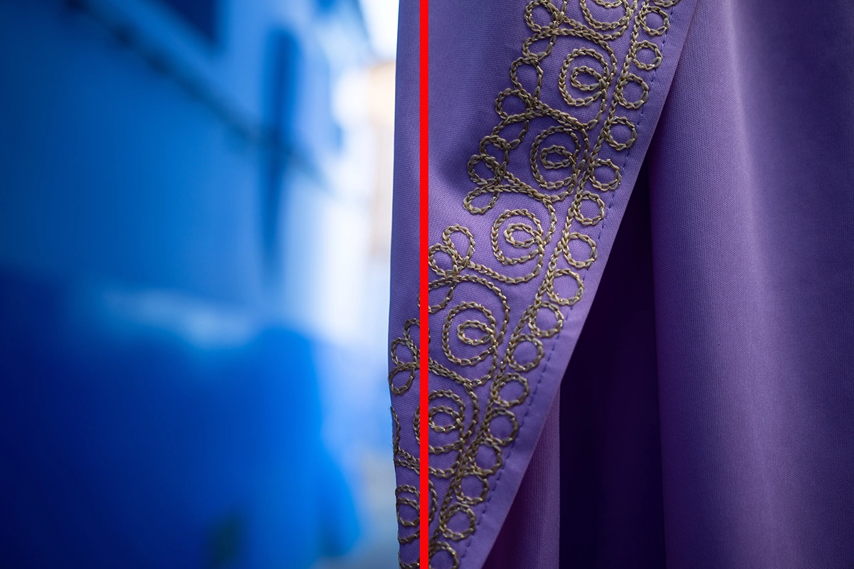 Gros plan d'un tissu brodé violet sur un mur bleu flou, divisé par une ligne verticale rouge pour illustrer le fractionnement de la composition.