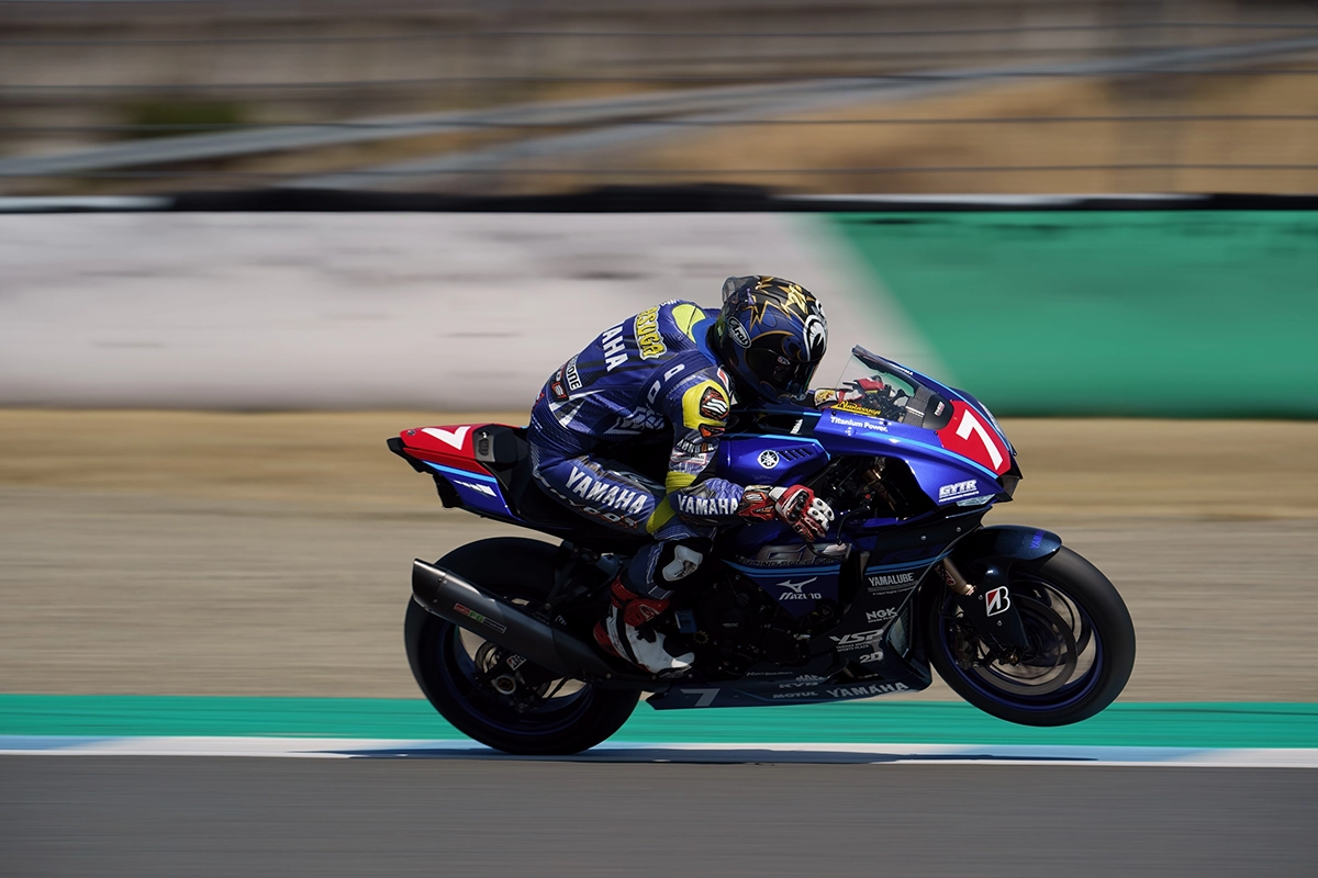 Panning photography of a motorcycle racer on a track, with motion blur background emphasizing speed and motion
