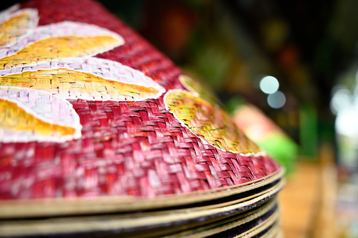 Close-up de um chapéu de tecido vietnamita pintado fotografado com a Tamron 28-75 mm F2.8 G2, mostrando detalhes e profundidade de campo rasa.