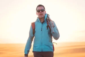 Travel photographer Ian Plant hiking at sunset with a tripod over his shoulder, photographed during an outdoor travel photography shoot.