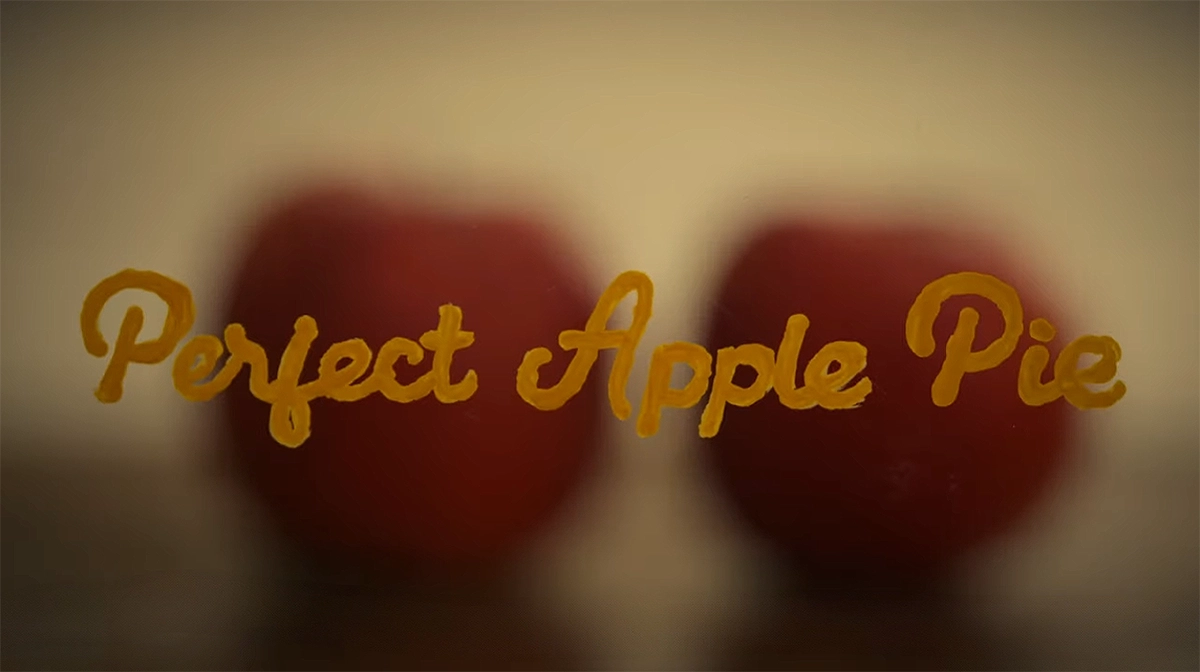 “Perfect Apple Pie” opening title over apples with soft bokeh blur in the background.