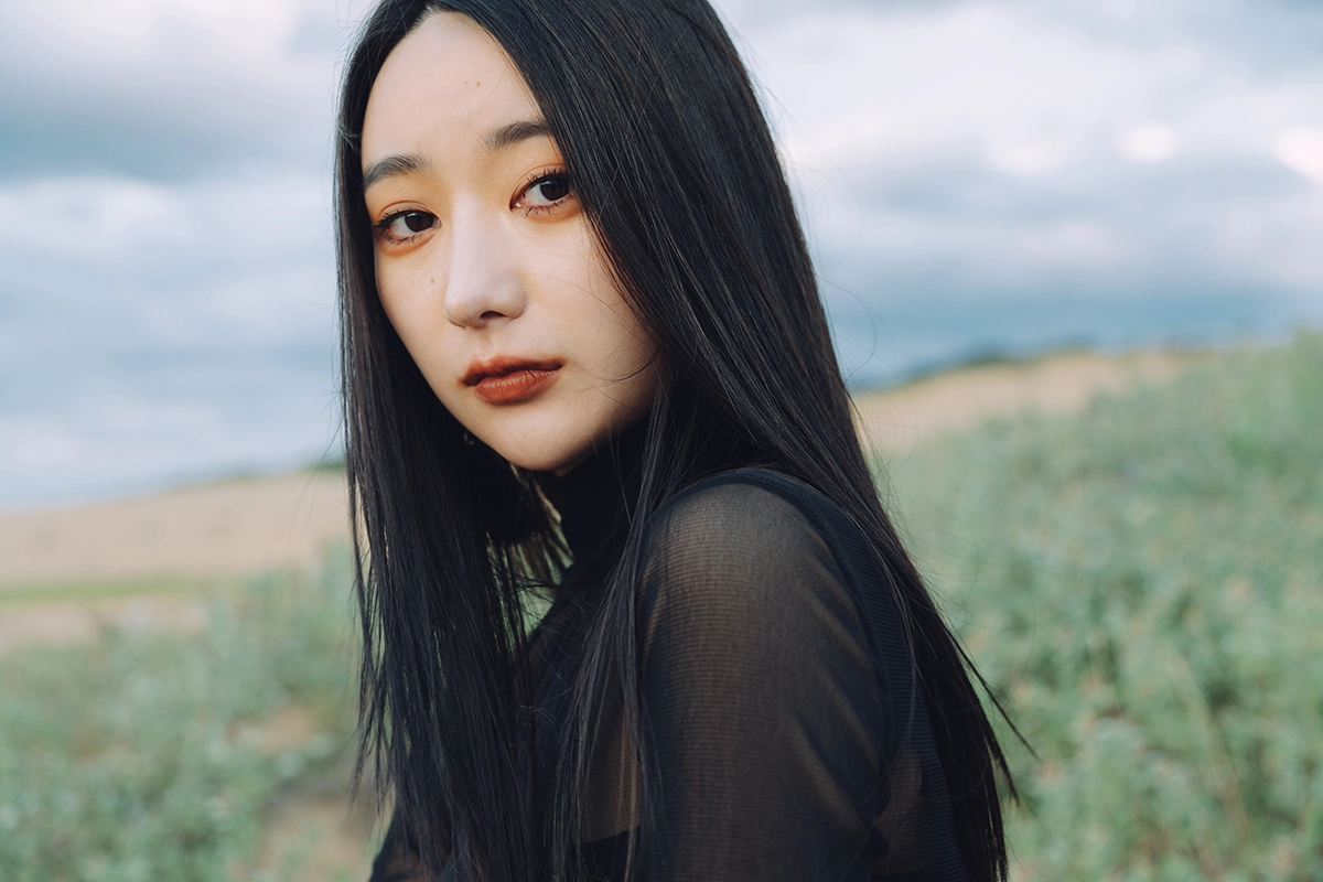 Portrait photo of a woman with a softly blurred background demonstrating subject isolation and shallow depth of field.